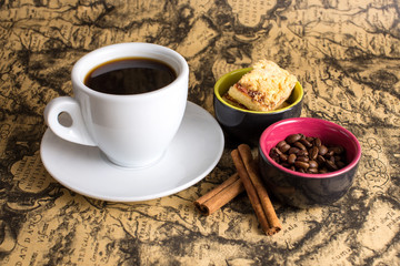 cup of hot espresso coffee, and cookie on a map