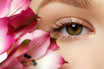 Fototapeta premium Gorgeous young model, beautiful woman eye with fresh pink flower
