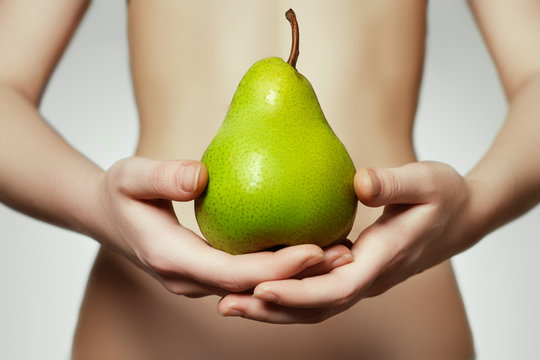 Hands holding pear. Portrait of young woman  holding pear