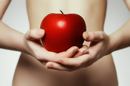 Hands holding red apple. Portrait of young woman  holding red apple