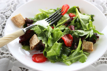 Green salad with strawberry pieces and a dressing of orange juic