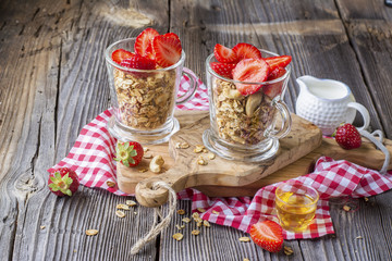 Obraz na płótnie Canvas Healthy breakfast dessert. Home crunchy granola with nuts and fresh strawberries