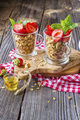 Healthy breakfast dessert. Home crunchy granola with nuts and fresh strawberries