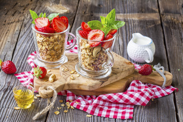Healthy breakfast dessert. Home crunchy granola with nuts and fresh strawberries