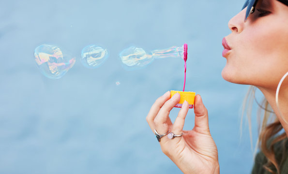 Young female blowing soap bubbles