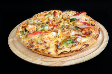 Seafood pizza on a wooden tray.