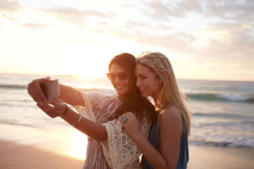 Happy young women taking selfie on the beach