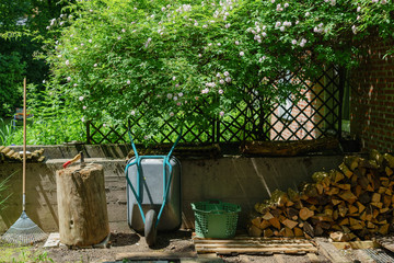 Hackstock mit Beil, Scheite und Stapel Brennholz in der Gartenec