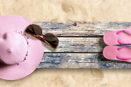 Summer beach accesories on old wooden boards on the sand beach