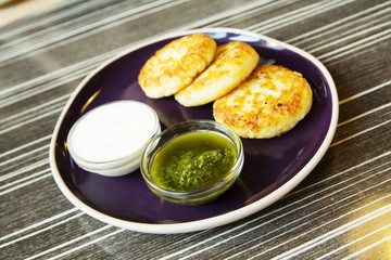 Homemade Salty Cheese Pancakes with sauce Pesto. Cheesecake pancakes with sour cream. Pancakes photographed close.