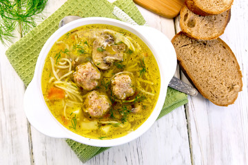 Soup with meatballs and noodles in bowl on napkin top
