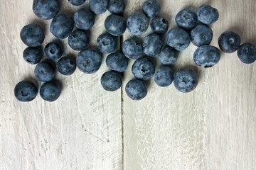Blueberries on light blue wooden texture with copyspace