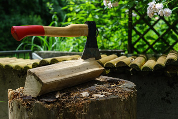 Hackstock mit Beil, Scheite und Stapel Brennholz 