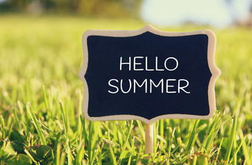 Wooden chalkboard sign with quote: HELLO SUMMER
