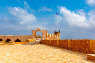 Old Firkas Fortress and The Greek flag in Old harbour of Chania in the morning, Crete, Greece