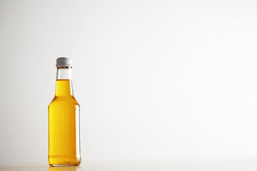 Unlabeled sealed bottle with apple lemonade isolated on white, presented on left side