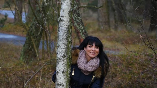 pretty smiling woman in autumn forest posing for photographer
