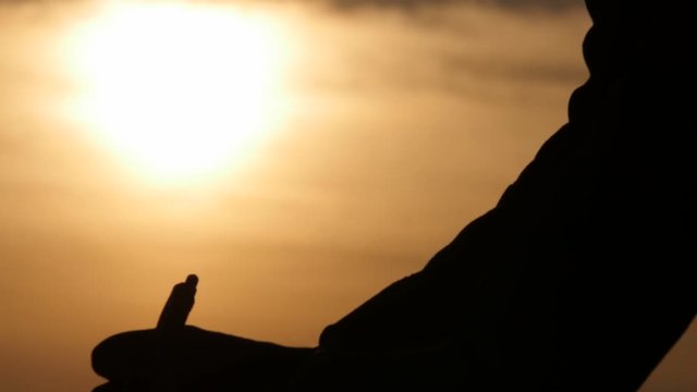 male hand silhouette slowly writing with bright sun  background