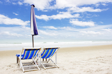 
two beach lounge chairs and tent on beach. rayong, Thailand