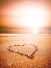 Love sign writing on sand at the sunset time, Love concept.