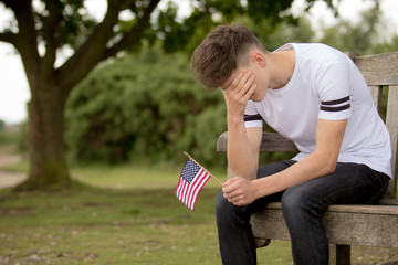 Depressed teenage boy with United States Flag