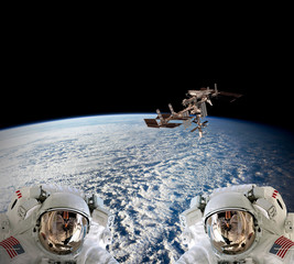 Planet Earth two astronauts spaceman helmet suit outer spacewalk international space station. Elements of this image furnished by NASA.
