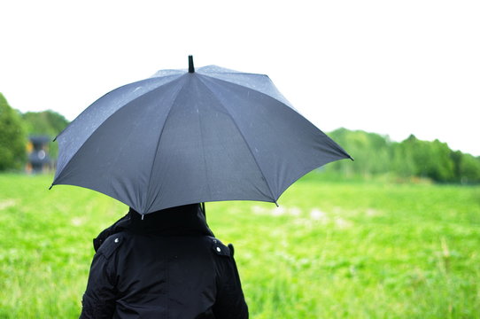 Frau mit Schirm im Regen