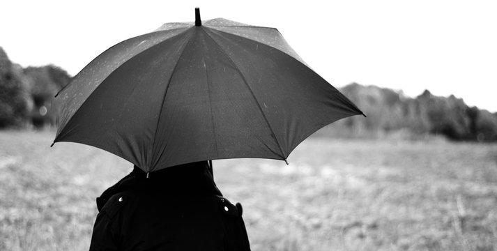 Frau mit Schirm im Regen