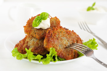 Potato pancakes with sour cream and lettuce