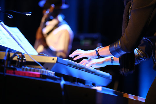 hands of musician playing keyboard in concert