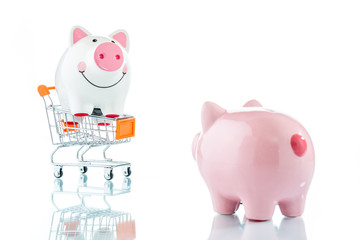 Piggy bank in a shopping trolley isolated on white