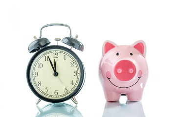 Alarmclock with piggybank on white background