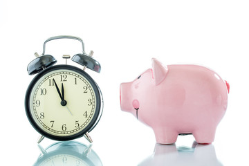 Alarmclock with piggybank on white background