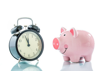 Alarmclock with piggybank on white background
