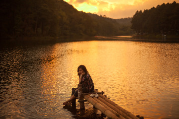 Fototapeta na wymiar Woman sitting on a pier