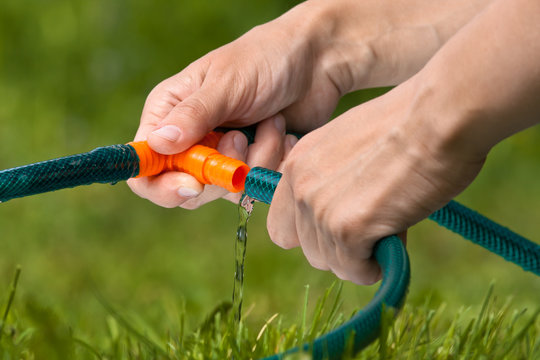 hands connecting hoses for irrigation of lawn or garden