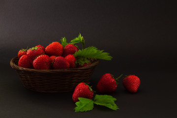 strawberries in a basket on a dark background