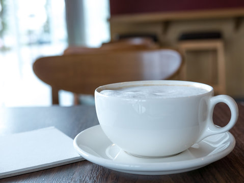 Open a blank white notebook with hot coffee on table