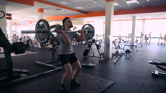 Young Male Athlete Trains With A Barbell In The Gym