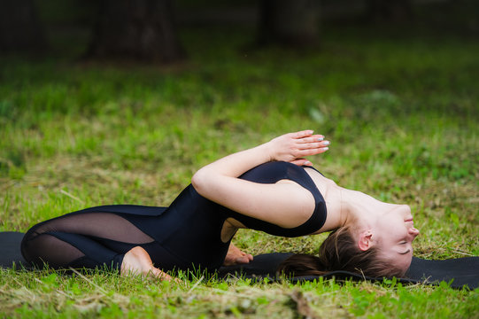 Young woman doing Yoga, reclining spinal twist position