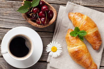 Croissants and coffee cup on wooden table