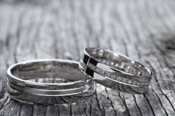 Two wedding rings on rustic wood, b&w