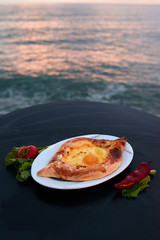 Adjarian khachapuri with eggs on table
