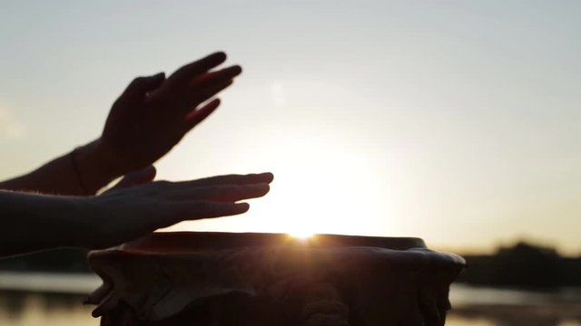 игра на джембе или атабаке на фоне природы во время заката