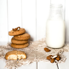Almond milk with cookies on white wooden background. Rustic.