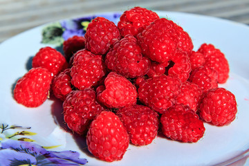 Ripe raspberries on a plate. Selective soft focus