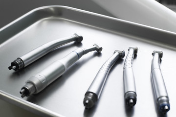 Dental turbine handpieces on metal tray closeup. Top view on ready for using set of dental tuebine handpieces on mesical tray.