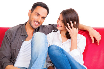 Smiling young man with girlfriend on sofa