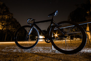 Fototapeta premium Fixie, Fixed Gear, Singlespeed Fahrrad nachts am Park