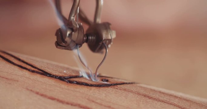 Artist using pyrography to decorate a Buddhist prayer wheel